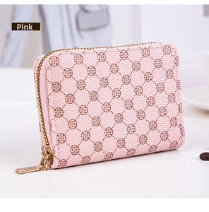 Close-up of pink faux leather wallet featuring heart patterns and golden zipper detail