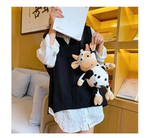 Close-up of a cute plush cow cartoon crossbody bag with soft black and white fur fabric