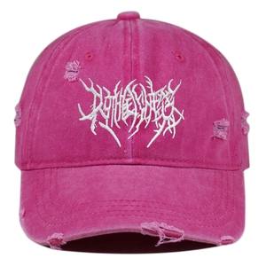 Close-up of distressed rose pink baseball cap with white 3D embroidery and worn edges