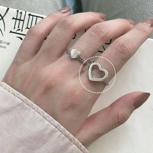 Detail of silver S925 heart rings including a solid and hollow design worn on hand