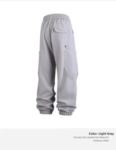 Detalle de pantalones cargo gris claro con cintura elástica y bolsillo con solapa