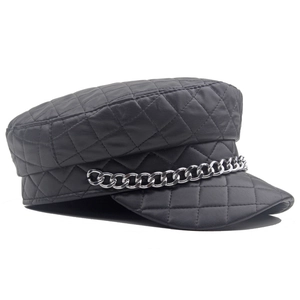 Quilted black leather fiddler hat with silver chain detail for a stylish winter look