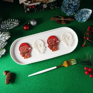 Christmas penguin cookie mold set with decorated icing cookies on a festive tray