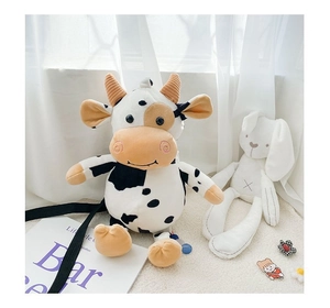 Close-up of plush cow cartoon bag featuring black and white spots and adjustable strap