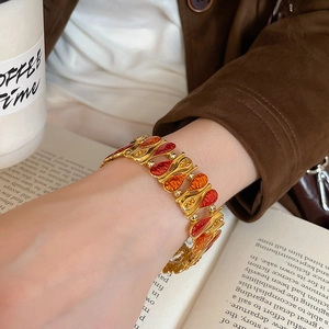 Detail of vintage gold drip glaze teardrop bracelet worn with elegant autumn styling