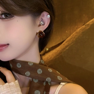 Close-up of amber resin teardrop earrings worn by a model with a vintage aesthetic