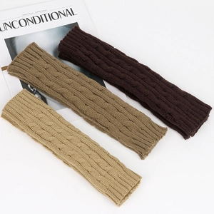 Detail of cable knit arm warmers in beige, brown and dark brown textured acrylic wool