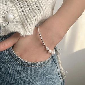 Detail of baroque pearl bracelet on model wrist with silver branch-shaped metal accents