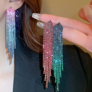 Macro detail of long tassel earrings with vibrant multi-color rhinestones in silver finish