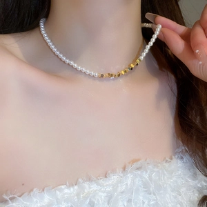 Close-up of pearl and gold geometric bead拼接 choker necklace on neck