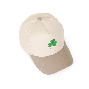 Detailed close-up of green shamrock embroidery on a contrast panel 5-panel trucker hat