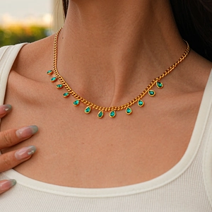 Detailed view of emerald green teardrop pendants on a gold-plated necklace for women