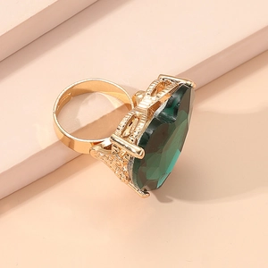Close-up of a pear-shaped green gemstone ring with an adjustable golden band