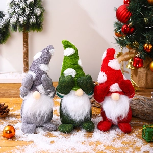Three plush Christmas gnomes with snowflake hats and long white beards on snow wood
