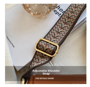 Details des verstellbaren gemusterten Stoffgurts mit Gold-Schnalle an brauner Tasche