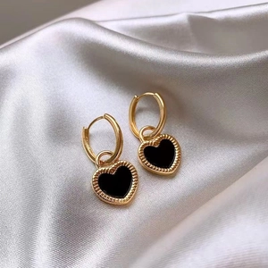 Retro asymmetric heart drop earrings in gold and black on white silk background