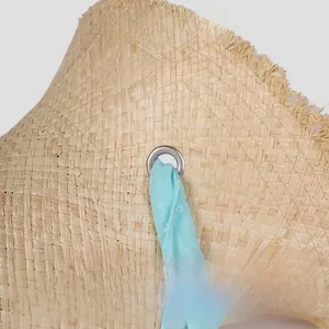 Detail of natural raffia straw weaving with light blue ribbon and silver metal eyelet
