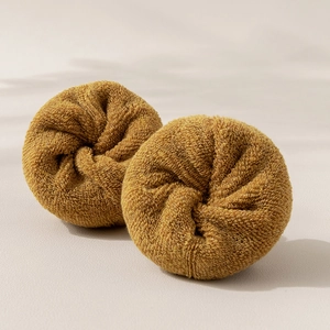 Pair of brown cotton terry sports socks rolled on a neutral light beige background