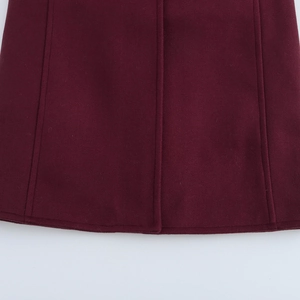 Detailed view of dark burgundy wool blend coat hem showing high-quality double stitching