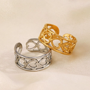 Adjustable hollow heart rings in gold and silver finish on elegant textured fabric