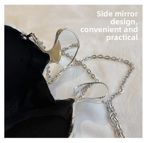 Detail view of black leather clutch bag with silver frame and integrated side mirrors
