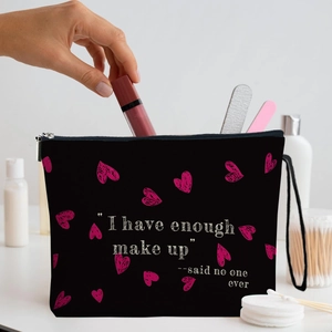 Black canvas makeup bag with pink hearts and funny slogan held by a model