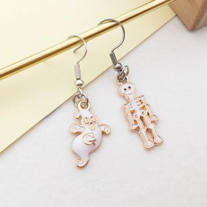 Close-up of asymmetrical Halloween earrings with white ghost and skull enamel charms