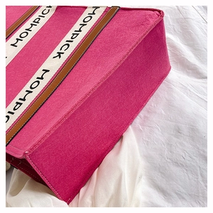 Detail view of rose pink felt tote bag with MOMPICK logo webbing and wide side gusset