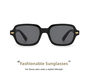 Detail of black rectangular sunglasses with golden metal rivets and dark lenses