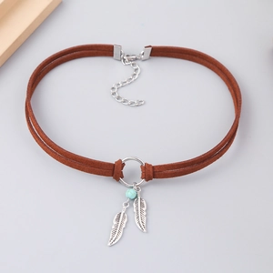 Detail of bohemian choker with turquoise bead and silver feather pendants on brown cord