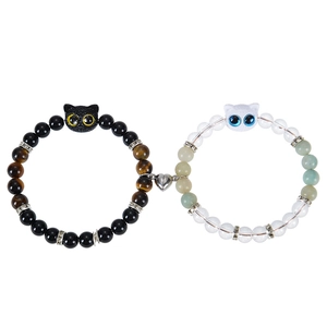 Close-up of magnetic heart clasp connecting black and white cat beaded couple bracelets