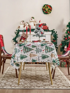 Detail of Christmas tree pattern tablecloth with festive fireplace and holiday decorations