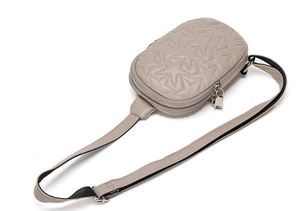Detail view of taupe star quilted leather chest bag with dual zippers and adjustable strap