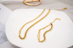 Close-up of gold layered chain featuring Cuban links and delicate bead strands