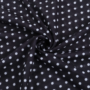 Macro shot of breathable mesh fabric with white polka dots on a black textile base