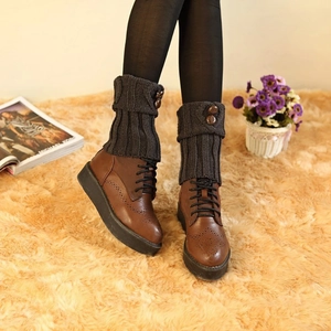 Detail of dark grey knit boot cuffs with buttons paired with brown brogue boots