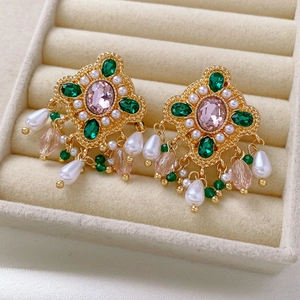 Vue détaillée de boucles d'oreilles vintage avec cristaux roses et perles en boîte