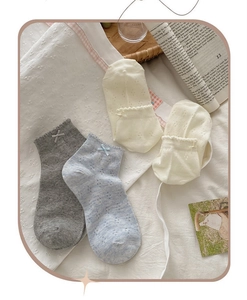 Detailed view of hollow mesh socks with bow knot in grey, light blue and beige colors