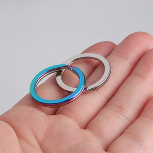 Polished stainless steel key rings in silver and rainbow colors held in palm for size