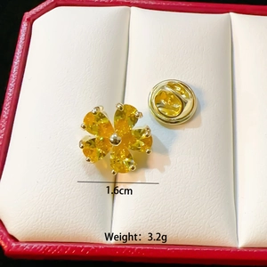 Minimalist gold flower brooch with yellow gemstone in a jewelry gift box