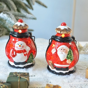 Lanternes de Noël lumineuses avec figurines de Père Noël et bonhomme de neige sur neige