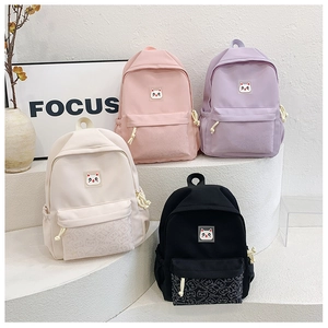 Four colorful children backpacks in beige, pink, purple and black with cute cat patches