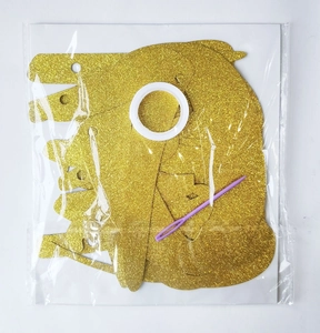 DIY banner kit with gold glitter cardstock, white ribbon, and a plastic threading needle