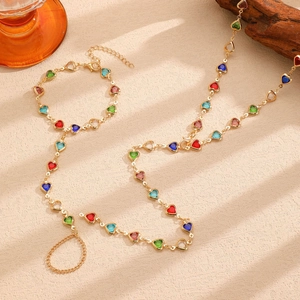 Detailed macro view of gold alloy necklace with multicolored heart-shaped gemstones
