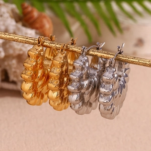 18K gold plated stainless steel hollow petal hoop earrings on a decorative stand