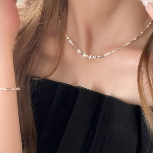 Détail du collier et bracelet minimalistes à perles cubes argentées portés par un mannequin