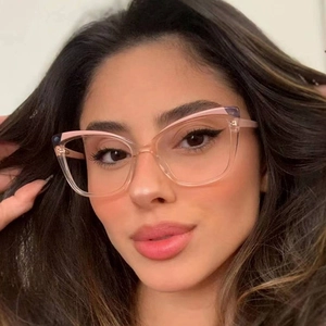 Close-up of trendy cat-eye glasses in transparent light pink on a female model