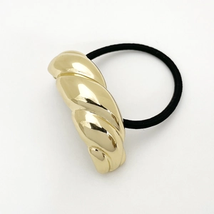 Macro shot of twist gold U-shaped alloy accent on a black elastic hair tie cord