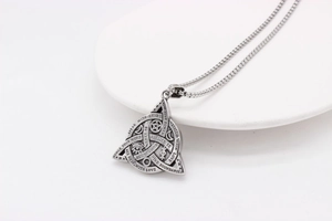 Macro shot of Viking triangle pendant with Celtic knots and positive engraved quotes