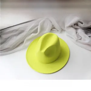 Macro shot of neon yellow wool fedora hat with wide brim and vibrant textured finish